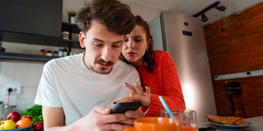 Un homme et une femme en train de regarder un téléphone