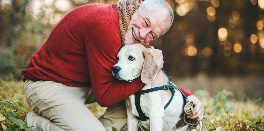 senior heureux en extérieur avec son chien