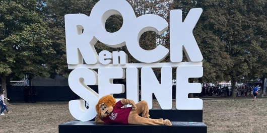 La mascotte lion de Generali devant le logo géant de Rock en Seine 2025