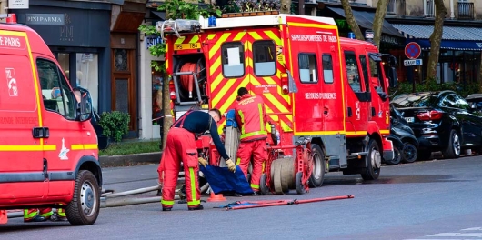un camion de pompier de paris stationné devant un restaurant