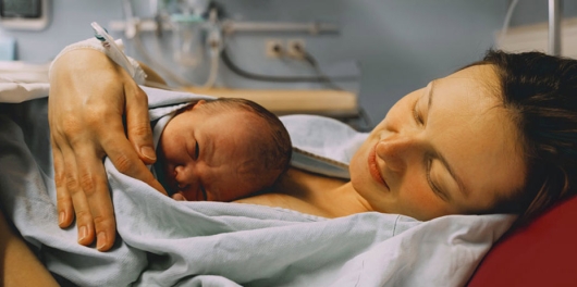 Femme à la maternité tenant son enfant nouveau né contre son sein