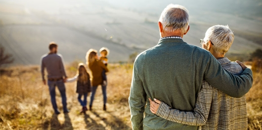Couple senior regardant leurs enfants et petits enfants en montagne