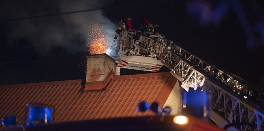 Feu de cheminée maîtrisé par des pompiers sur un toit