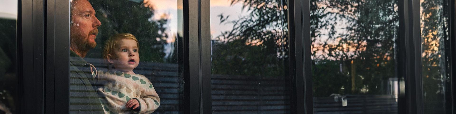 Père portant un jeune enfant et regardant l'horizon