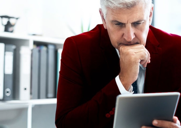 Un homme dans son bureau consultant sa tablette