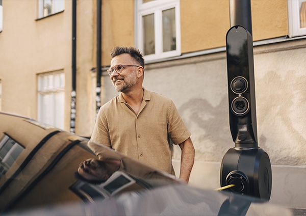 un homme devant sa voiture électrique