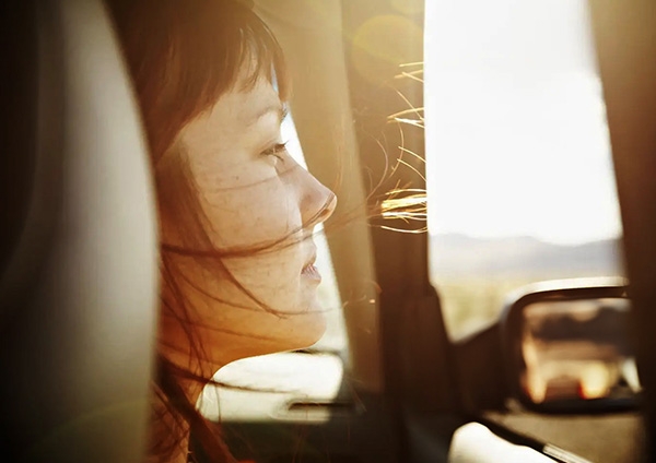 une femme qui regarde par la fenêtre de sa voiture