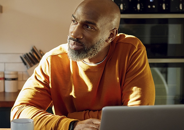 un homme chez lui devant un ordinateur