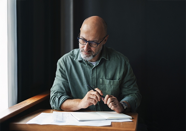 un homme qui regarde des documents l'air sérieux