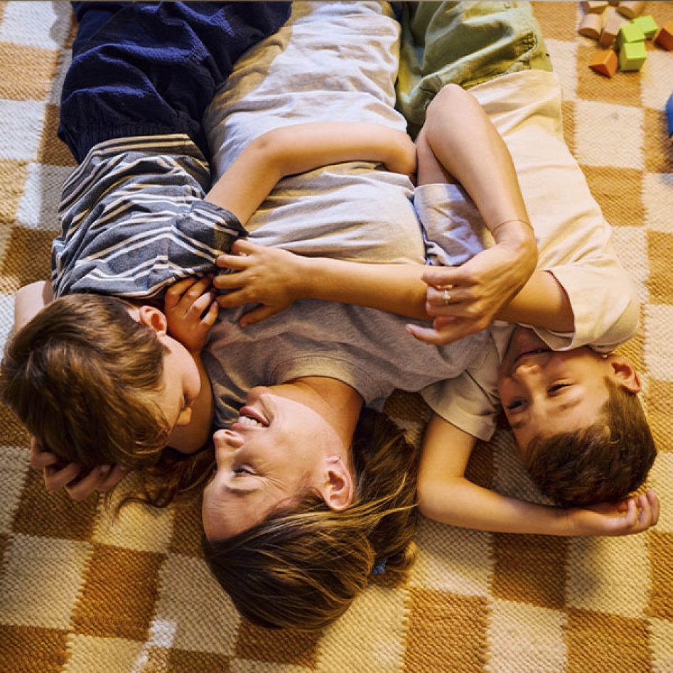 Une mère et ses deux fils sur un tapis