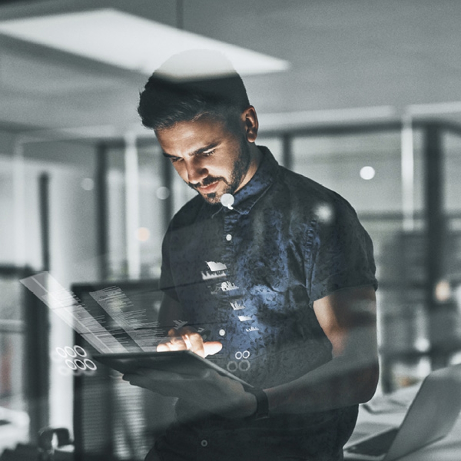 un homme au travail qui regarde sa tablette