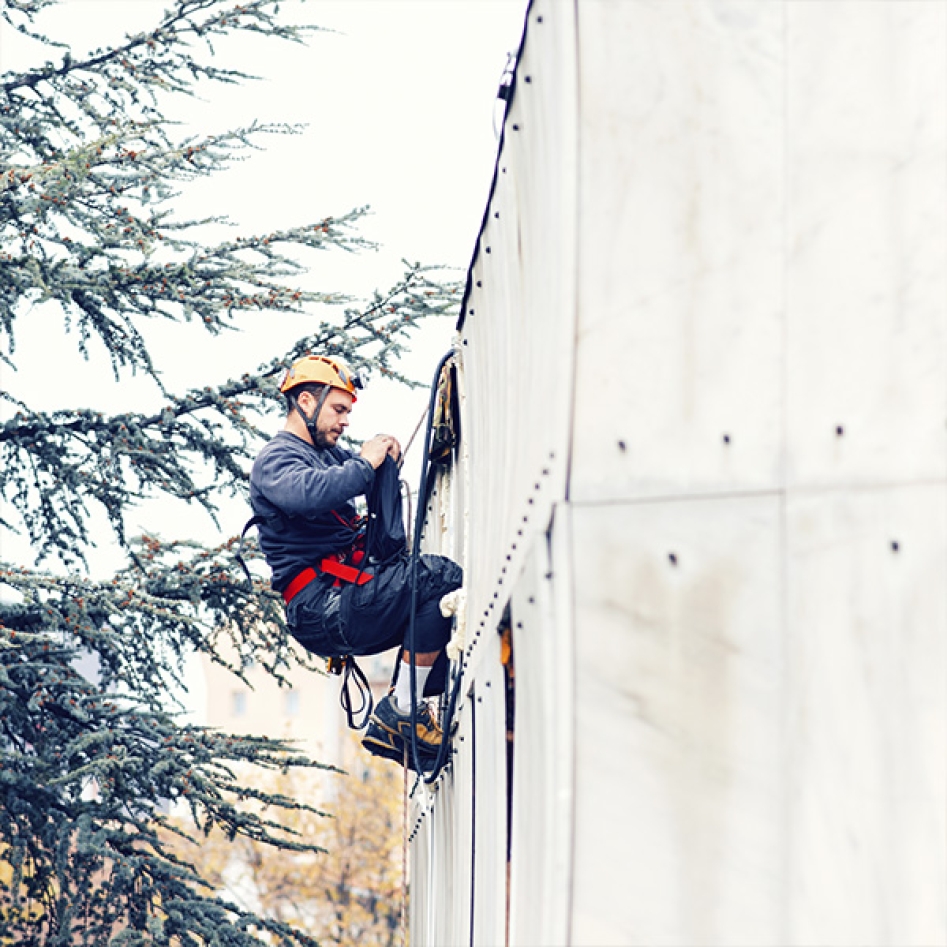 un homme grimpant à un mur dans le cadre de son travail